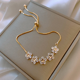 Pulsera minimalista de oro ajustable con dije floral y estrella y cristales para mujer