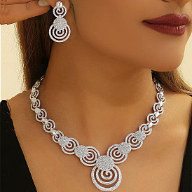 Комплект из ожерелья и серег-гвоздиков из сплава со стразами и кристаллами в форме вихря