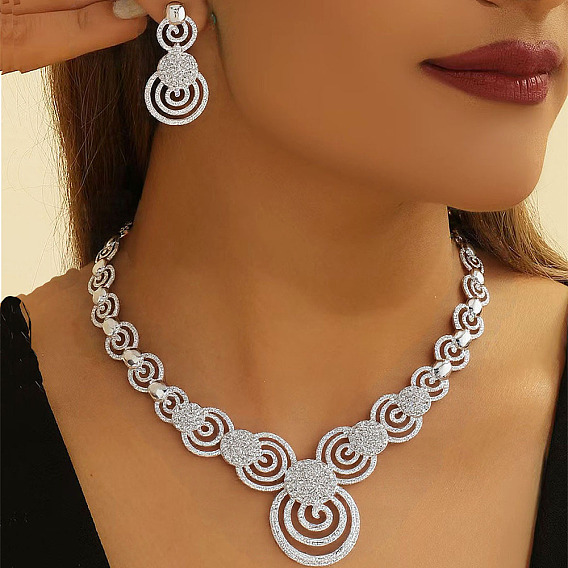 Комплект из ожерелья и серег-гвоздиков из сплава со стразами и кристаллами в форме вихря
