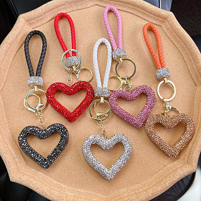 Heart-shaped keychain with hollowed-out ceramic and rhinestone embellishments on leather strap.