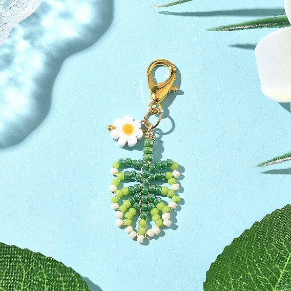 Подвеска в виде листа из бисера, выполненная вручную на ткацком станке, с бусинами из цветочного стекла миллефиори и застежками-карабинами из сплава