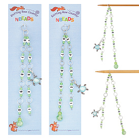 Окрашенное распылением кракелюрное стекло и акриловые звенья, вязальные цепочки со счетчиками рядов, латунное связующее кольцо, маркер для запирания петель, шкентеля сплава с стразами, черепаха