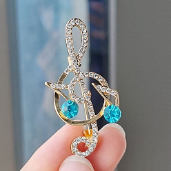 Голубой Брошь в виде музыкальной ноты из сплава и стеклянных страз, голубой, 49x27 mm.